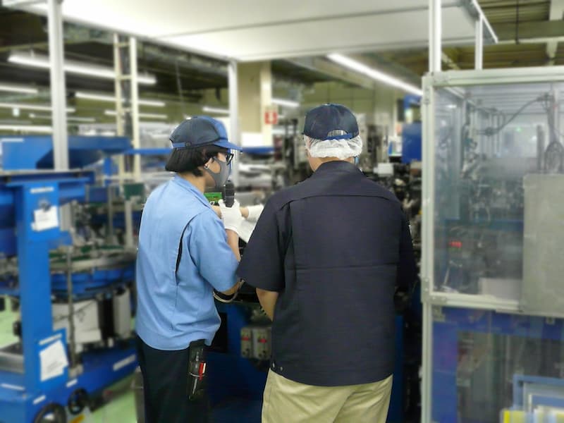製造工程の案内を受けている様子